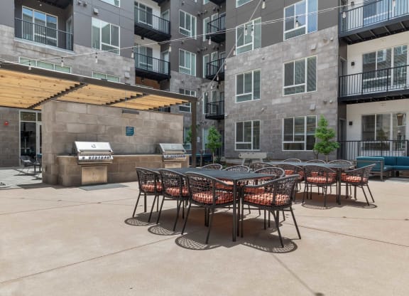 an outdoor patio with tables and chairs at an apartment building