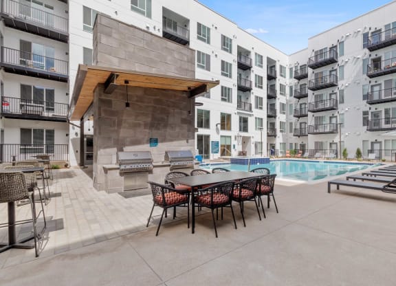 our apartments have a pool and a patio with a table and chairs
