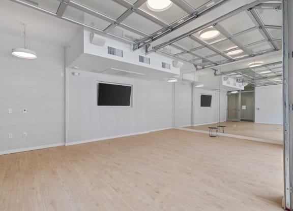 a large room with a wooden floor and a tv on the wall