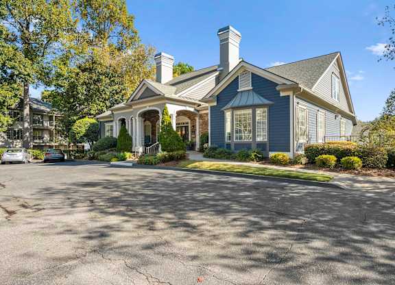 the front of a house with a driveway and a blue house