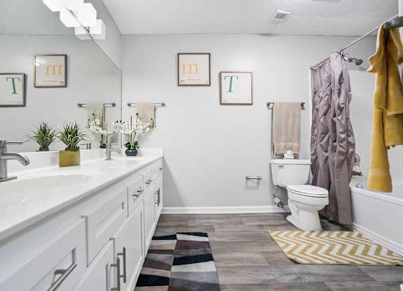 a bathroom with a toilet and a sink and a shower