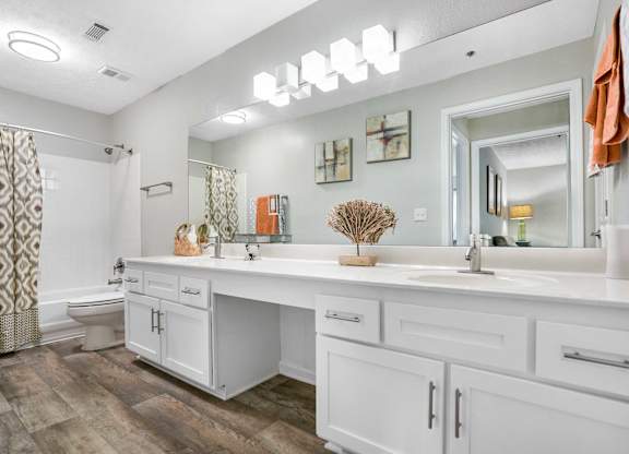 a white bathroom with a large mirror and a sink