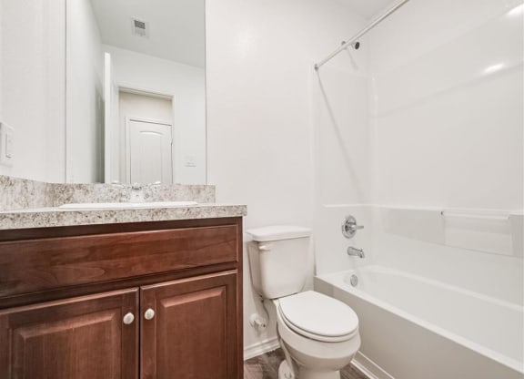 a bathroom with a toilet sink and bathtub at The Village at Granger Pines, Texas, 77302