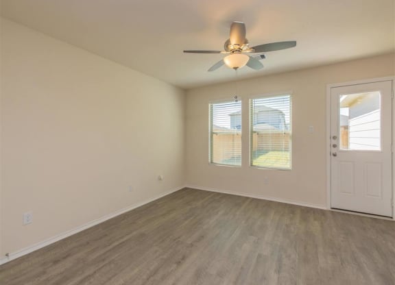 an empty room with a ceiling fan and two windows at The Village at Granger Pines, Texas, 77302