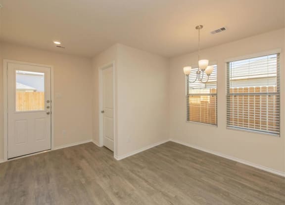 a bedroom with a door and two windows at The Village at Granger Pines, Texas, 77302