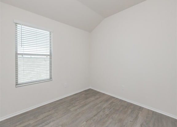an empty room with a window and a wooden floor at The Village at Granger Pines, Texas, 77302