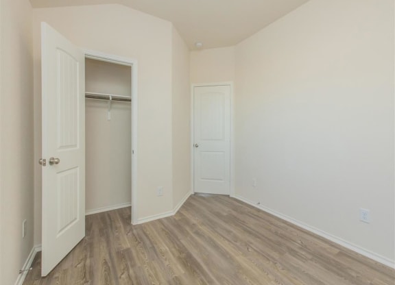 a bedroom with a closet and a door open at The Village at Granger Pines, Conroe, TX 77302
