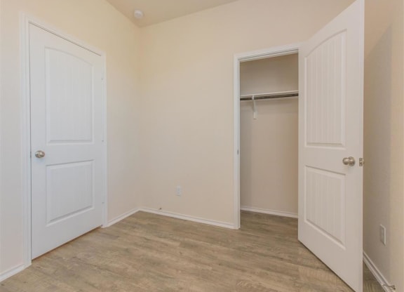 a bedroom with two doors and a closet at The Village at Granger Pines, Texas, 77302