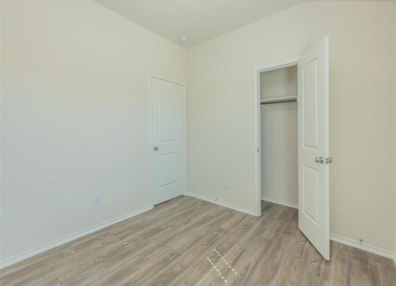 a bedroom with white walls and a wooden floor at The Village at Granger Pines, Conroe, 77302