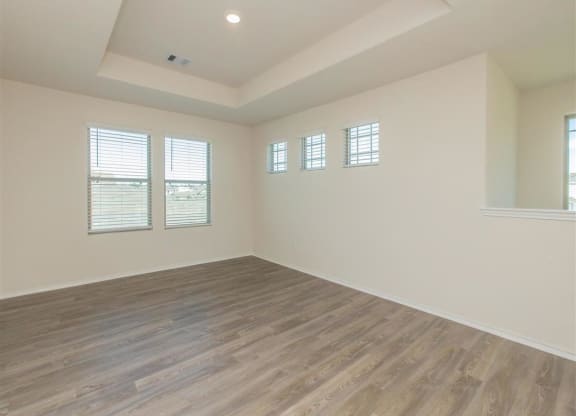 an empty room with white walls and a wooden floor at The Village at Granger Pines, Texas, 77302