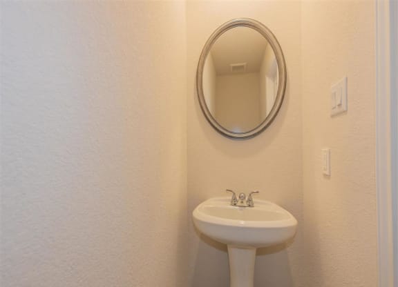 a bathroom with a sink and a mirror at The Village at Granger Pines, Texas, 77302