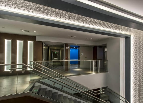 the lobby of a building with stairs and a blue door