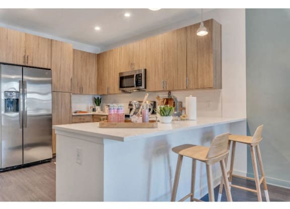 a kitchen with two bar stools and a refrigerator