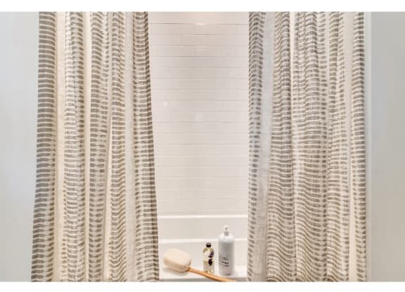 a bathroom with a shower curtain and a white tub