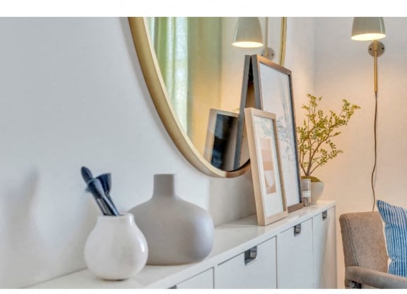 a white shelf with a mirror and a vase on it