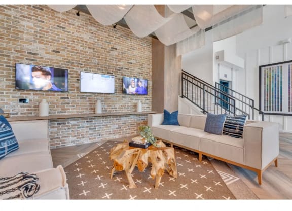 a living room with a brick wall and a couch and a table