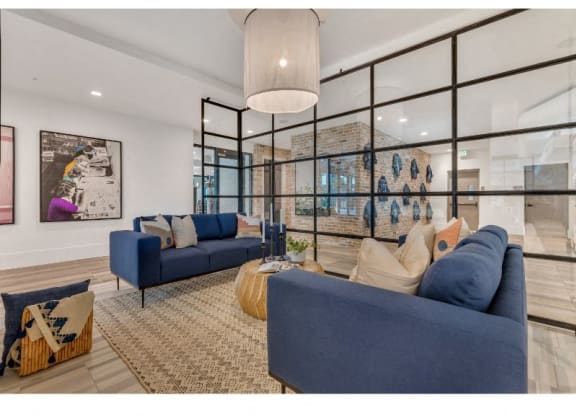 a living room with blue couches and a large glass window