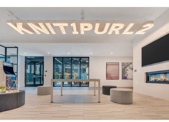 a large lobby with a table and a fireplace