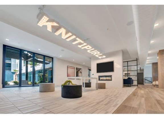 a large lobby with a tv and a glass door