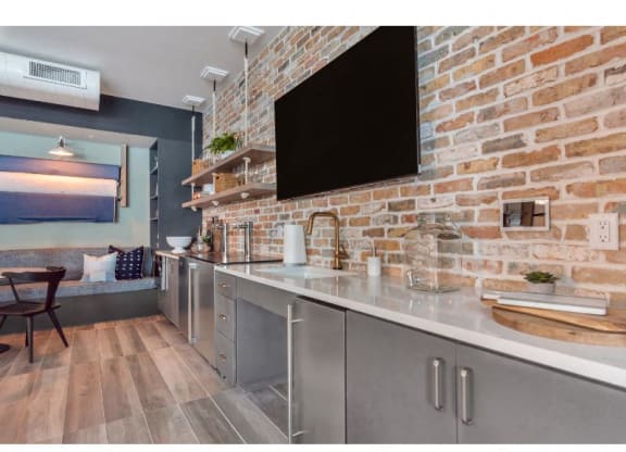 a kitchen with stainless steel counter tops and a brick wall