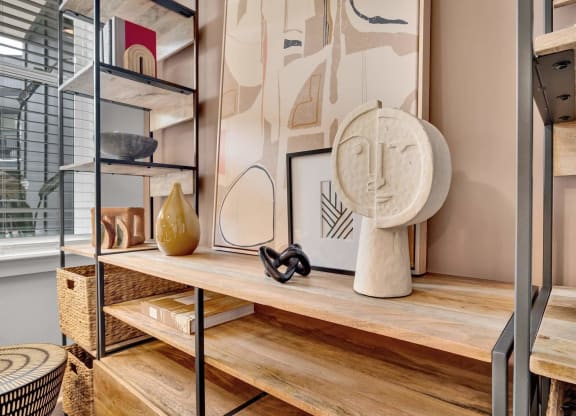 a living room with a wooden shelf and a table with a sculpture