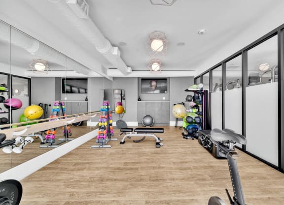 a workout room with a wood floor and mirrored walls and exercise equipment