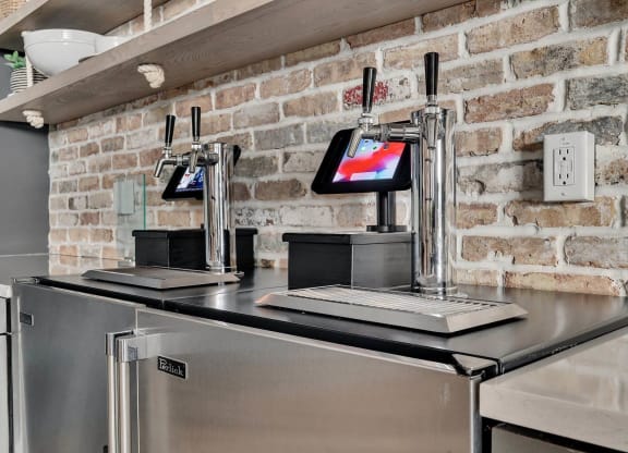 a kitchen with a stainless steel counter top and a brick wall