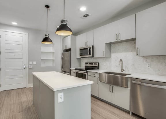 a kitchen with white cabinets and stainless steel appliances