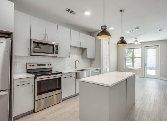 a kitchen with white cabinets and stainless steel appliances
