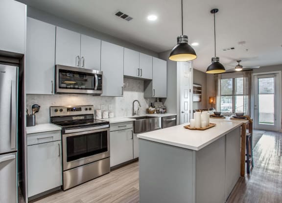 a kitchen with white cabinets and stainless steel appliances
