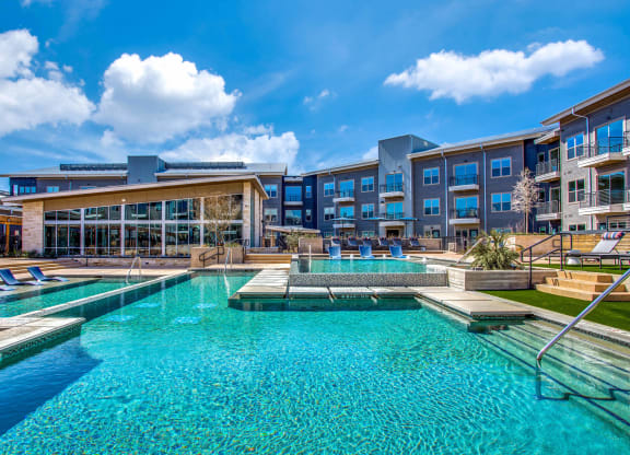 a large swimming pool with a building in the background