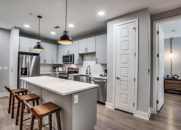 a kitchen with a large island with three stools