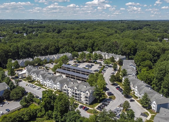 an aerial view of a building surrounded by trees and a parking lot