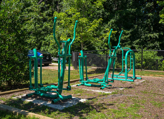 a playground with some exercise equipment in a park