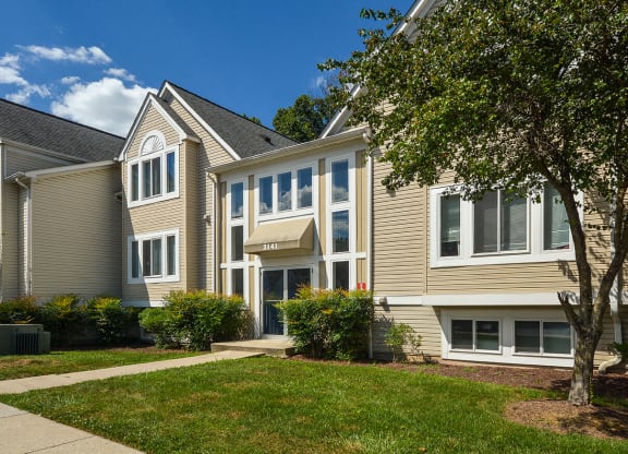 a view of the exterior of an apartment building with a sidewalk