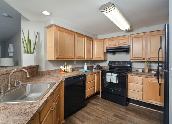 a kitchen with wooden cabinets and black appliances