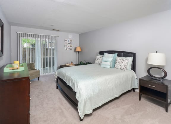 a bedroom with a bed and a dresser and a window