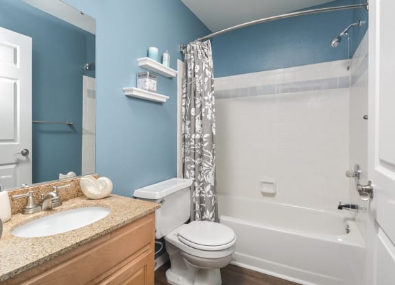 a bathroom with a toilet and a shower and a sink