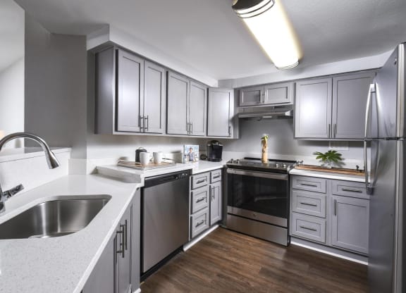a kitchen with stainless steel appliances and white counter tops