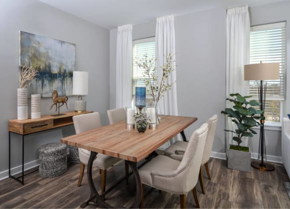 a dining room with a wooden table and white chairs