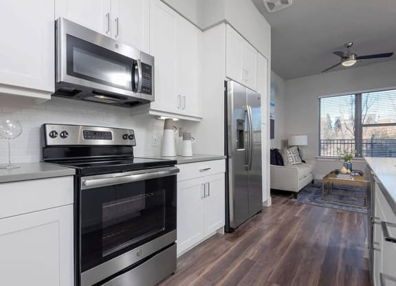 a kitchen with stainless steel appliances and white cabinets