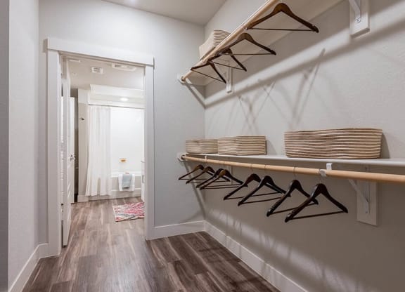 a laundry room with baskets on a rack and a door to a bathroom