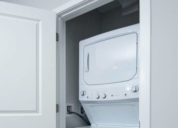a white washer and dryer in a room with a door