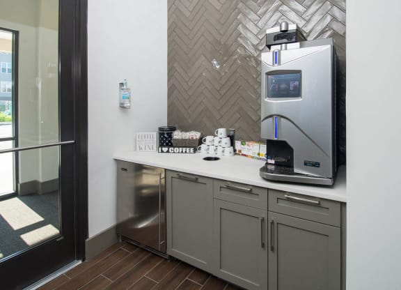 a kitchen with a coffee maker and a sink in a hotel room