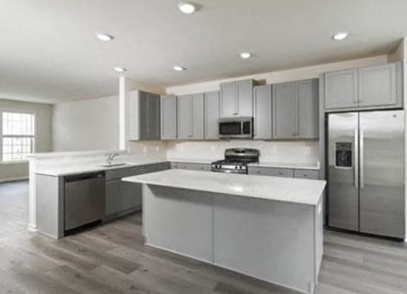 a kitchen with stainless steel appliances and white counter tops