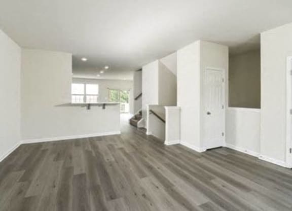 an empty living room with white walls and wooden floors