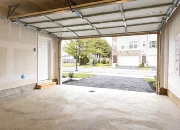 an empty garage with the door open to the street