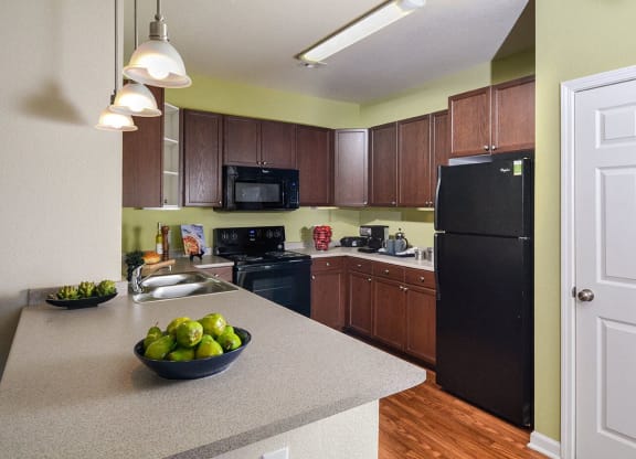 a kitchen with a counter top and a black refrigerator