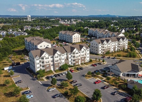 an aerial view of apartment buildings in a parking lot