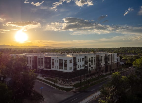 an aerial view of a building with the sun setting behind it